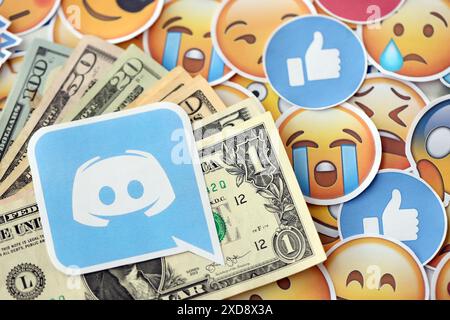 KIEW, UKRAINE - 20. APRIL 2024 Discord-Logo und viele usd-Geldscheine. Symbol der berühmten sozialen Netzwerkplattform und Dollarwährungsscheine auf vielen Emoji-Reaktionen aus nächster Nähe Stockfoto