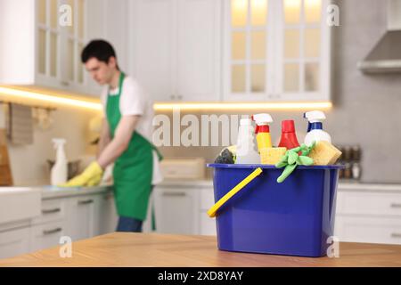 Professioneller Hausmeister, der in der Küche arbeitet, konzentriert sich auf Eimer mit Zubehör. Reinigungsservice Stockfoto