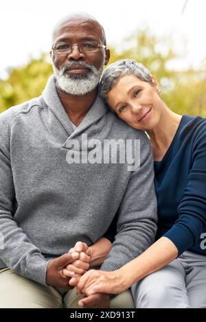 Reifes Paar, Portrait und Liebe im Freien für Ruhestand, Urlaub und Bindung mit Umarmung und Hände halten. Interrassische Ehe, Gesicht und Menschen in Stockfoto