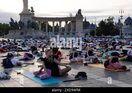 BUDAPEST, 21. Juni 2024 (Xinhua) -- Menschen üben Yoga bei Sonnenaufgang, um den Internationalen Tag des Yoga auf dem Heldenplatz in der Innenstadt von Budapest, Ungarn, 21. Juni 2024 zu feiern. (Foto: Attila Volgyi/Xinhua) Stockfoto