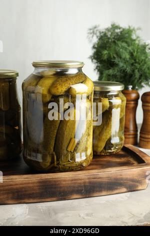 Eingelegte Gurken in Gläsern auf grauem Tisch Stockfoto