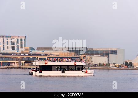 Touristenboot auf Dubai Creek mit Festival City Mall im Hintergrund, VAE. Stockfoto