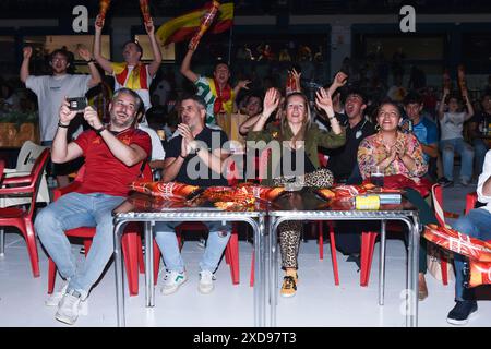Madrid, Spanien. Juni 2024. Fußballfans reagieren, während sie das Spiel der Gruppe B der UEFA Euro 2024 zwischen Spanien und Italien am 20. Juni 2024 auf einem Bildschirm auf einer Eislaufbahn in Madrid, Spanien, ansehen. Gustavo Valiente/Xinhua/Alamy Live News Stockfoto