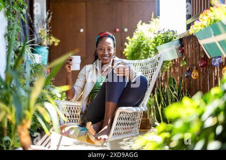 Wunderschöne Frau, die sich auf dem Balkon zu Hause entspannt Stockfoto