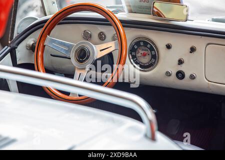 Oldtimer-Armaturenbrett mit Holzlenkrad und klassischem Tachometer Stockfoto