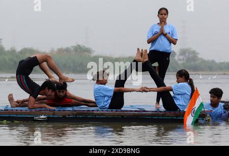 Neu-Delhi, Indien. Juni 2024. Die Menschen nehmen an der Yoga-Übungsveranstaltung Teil, die anlässlich des Internationalen Tages des Yoga im Yamuna-Fluss in Sonia Vihar stattfindet. Der Internationale Tag des Yoga wird seit 2015 weltweit jährlich am 21. Juni gefeiert, nachdem er 2014 in der Generalversammlung der Vereinten Nationen ins Leben gerufen wurde. (Foto: Naveen Sharma/SOPA Images/SIPA USA) Credit: SIPA USA/Alamy Live News Stockfoto