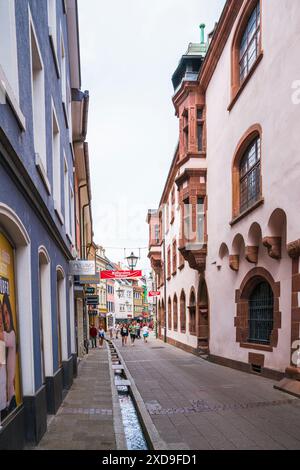 Freiburg im Breisgau, Deutschland, 23. Juli 2023, bunte historische Hausfassaden in engen Gassen in der Altstadt. Neben Wasser des Baches, das durchfließt Stockfoto