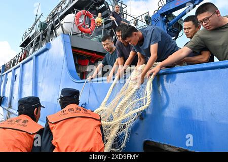 (240621) -- SANSHA, 21. Juni 2024 (Xinhua) -- Gesetzesvollstrecker der chinesischen Küstenwache geben die entnommenen Fischernetze an chinesische Fischer im chinesischen Ren'ai Jiao und dem umliegenden Territorialmeer zurück, 11. Juni 2024. Vor kurzem beschädigten Mitarbeiter des illegal geerdeten philippinischen Marinetransportschiffs im chinesischen Ren'ai Jiao und im umliegenden Territorialmeer wiederholt die Netze der chinesischen Fischer und setzten die illegal beschafften Fischernetze in die nahe gelegenen Gewässer ihres Schiffes ein, um die Strafverfolgung der chinesischen Küstenwache (CCG) zu behindern. Die Polizei der CCG hat diese illegal beschafften Fis zurückgeholt Stockfoto