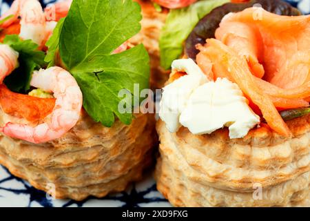Blätterteigtörtchen oder Canapes mit Räucherlachs, Garnelen und Speck. Stockfoto