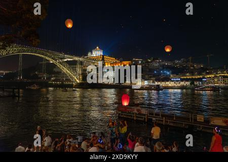 06.23.2023. Porto, Portugal: Festa de Sao Joao do Porto viele glückliche Menschen auf der Straße mit fliegenden Laternen am Abend. Stockfoto