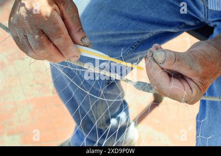 Italien, Ligurien, Laigueglia, Fischer seine Netze flicken Stockfoto