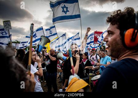 Cäsarea, Israel. Juni 2024. Während einer Protestkundgebung an der Seite des israelischen Ministerpräsidenten Benjamin NetanyahuÕs in Caesarea singt eine israelische Protestlerin und hebt den Arm und ruft ihn zum Rücktritt auf. Donnerstag, 20. Juni 2024. Netanjahu hat wiederholt gesagt, dass keine Wahlen stattfinden sollten, solange der Krieg in Gaza noch andauert. Die nächsten Parlamentswahlen sind offiziell für Oktober 2026 geplant. Foto: Eyal Warshavsky./Alamy Live News Stockfoto