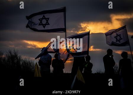 Israelische Demonstranten schwenken ihre Nationalflagge während einer Protestkundgebung an der Seite des israelischen Ministerpräsidenten Benjamin NetanyahuÕs in Caesarea und rufen ihn zum Rücktritt auf. Donnerstag, 20. Juni 2024. Netanjahu hat wiederholt gesagt, dass keine Wahlen stattfinden sollten, solange der Krieg in Gaza noch andauert. Die nächsten Parlamentswahlen sind offiziell für Oktober 2026 geplant. Foto: Eyal Warshavsky./Alamy Live News Stockfoto