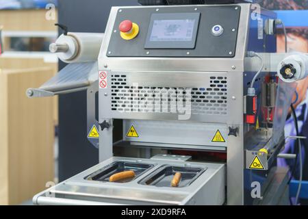 Automatisierte Lebensmittelverpackungsmaschine, die speziell für das effiziente Verschließen und Verpacken von Lebensmitteln wie Würstchen entwickelt wurde Stockfoto