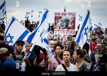 Ein israelischer Demonstrant hält ein Schild mit dem israelischen Ministerpräsidenten Benjamin NetanyahuÕs, das auf Hebräisch Ò steht. Wegen Ihnen sterben wir aus unserem livesÒ, während einer Protestkundgebung neben seiner Villa in Caesarea, die ihn zum Rücktritt aufruft. Donnerstag, 20. Juni 2024. Netanjahu hat wiederholt gesagt, dass keine Wahlen stattfinden sollten, solange der Krieg in Gaza noch andauert. Die nächsten Parlamentswahlen sind offiziell für Oktober 2026 geplant. Foto: Eyal Warshavsky./Alamy Live News Stockfoto