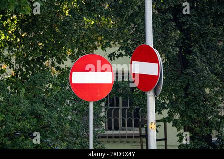 Zwei rote "No Entry"-Schilder an einem Pole vor Green Trees Stockfoto