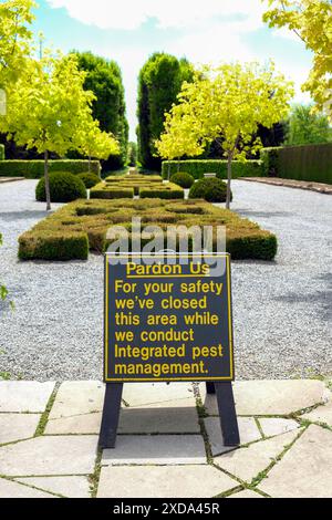 Beschilderung zur integrierten Schädlingsbekämpfung in einem öffentlichen Garten. Buchsbaumfäule und Buchsbaummotte und ihre raupe haben diese Pflanzen dezimiert. Stockfoto