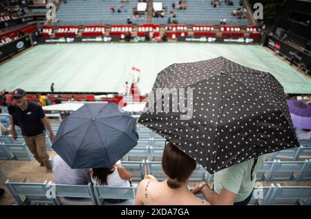 Berlin, Deutschland. Juni 2024. Tennis: WTA Tour, Singles, Frauen, Viertelfinale. Zuschauer schützen sich mit Regenschirmen vor Regen. Quelle: Hannes P. Albert/dpa/Alamy Live News Stockfoto