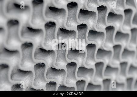 3D-gedrucktes wellenförmiges Gitter aus Metall, dreidimensionales durchbrochenes Gitter aus Nahaufnahme. Abstrakter Hintergrund moderner Technologie. Stockfoto