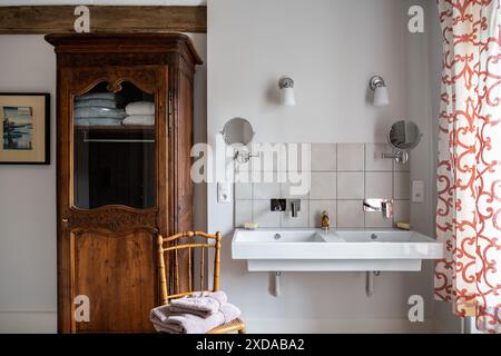 Modernes Becken mit antikem Schrank in renoviertem Hotel aus Stein, das aus dem Jahr 1770 in Saulieu, Burgund, Frankreich stammt. Stockfoto