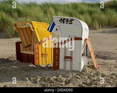 Zwei Liegen, eine gelbe und eine weiße, nebeneinander am Sandstrand vor grasbewachsenen Dünen, Juist, ostfriesland, deutschland Stockfoto