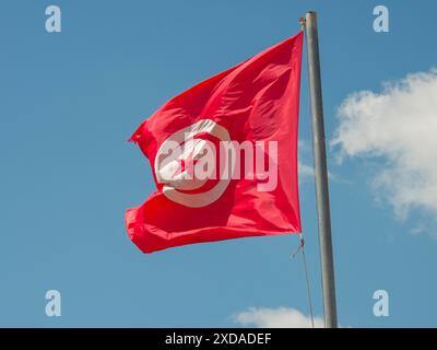 Die große rote Flagge Tunesiens flattert im Wind gegen einen klaren Himmel, Tunis, Tunesien Stockfoto