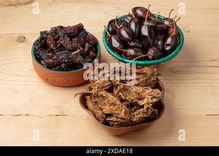 Schüsseln mit einer Variation mexikanischer getrockneter Chilischoten auf hölzernem Hintergrund Stockfoto