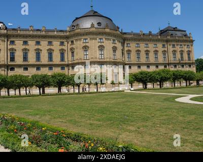Prächtiges Barockschloss mit gepflegten Gärten und blühenden Blumen im Vordergrund an einem sonnigen Tag, würzburg, bayern, deutschland Stockfoto