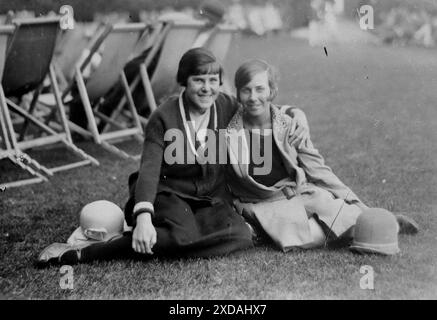 Hüte und Mäntel, zwei Damen sitzen auf einem Rasen mit Liegestühlen im Hintergrund. Mode und Kultur. Aus einer Sammlung von Schnappschussfotos einer Gruppe von Frauen, 1928. Es gab nur wenige Anmerkungen auf den Fotos, aber die Frauen schienen als Gruppe zu reisen und hatten eindeutig eine Vorliebe für die englische Grafschaft Kent. Einige der Fotos deuten darauf hin, dass sie Feministinnen ihrer Zeit waren, und obwohl sie weitgehend unbekannt sind, habe ich sie aufgenommen, da sie einige der Mode der Zeit repräsentieren. Stockfoto