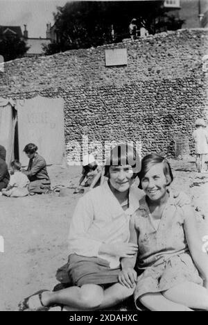 Sommerkleidung, zwei Damen mit einer hohen Wand dahinter und einem Schild mit der Aufschrift „Baden verboten“. August. Mode und Kultur. Aus einer Sammlung von Schnappschussfotos einer Gruppe von Frauen, 1928. Es gab nur wenige Anmerkungen auf den Fotos, aber die Frauen schienen als Gruppe zu reisen und hatten eindeutig eine Vorliebe für die englische Grafschaft Kent. Einige der Fotos deuten darauf hin, dass sie Feministinnen ihrer Zeit waren, und obwohl sie weitgehend unbekannt sind, habe ich sie aufgenommen, da sie einige der Mode der Zeit repräsentieren. Stockfoto