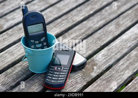 Alte Handys auf einem alten verwitterten Holztisch Stockfoto