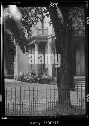 Mehrstöckiges Haus, möglicherweise im Garden District, New Orleans, Säulen, Palmen und Balkone, New Orleans. Genthe Fotosammlung. Stockfoto