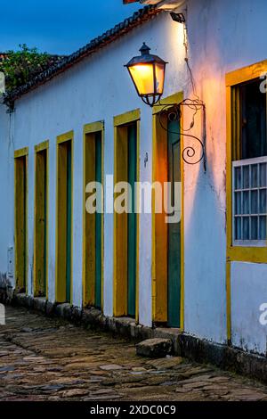 Dämmerung in der historischen Stadt Paraty mit Kolonialhäusern und von Laternen beleuchteten Fassaden Stockfoto