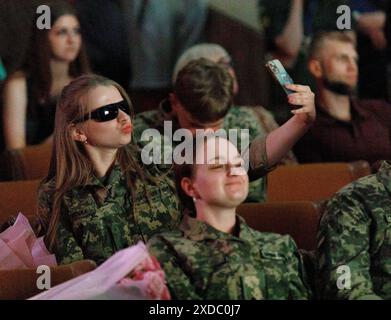 KIEW, UKRAINE - 21. JUNI 2024 - Eine Frau in Militäruniform und Sonnenbrille macht ein Entengesicht während der Abschlussfeier der Lieutenants am Militärinstitut der Nationalen Taras-Schewtschenko-Universität Kiew, Kiew, Hauptstadt der Ukraine. Stockfoto