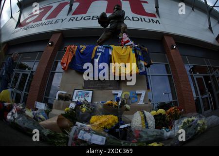 Leeds, Großbritannien. Juni 2024. AMT Headingley Rugby Stadium, Leeds, West Yorkshire, 21. Juni 2024. Betfred Super League Leeds Rhinos gegen Leigh Leoparden Rob Burrows Tribute, die vor dem Spiel an der Statue des ehemaligen Leeds Rhinos Spielers John Holmes liegen, in Erinnerung an den Ex-Leeds Rhinos und den England Rugby League Spieler. Quelle: Touchlinepics/Alamy Live News Stockfoto