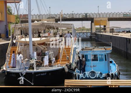 Ein Dahabiya-Zweimastsegelboot und sein Schlepper in den aufsteigenden Gewässern der Esna-Schleuse am Nil, Ägypten. Stockfoto