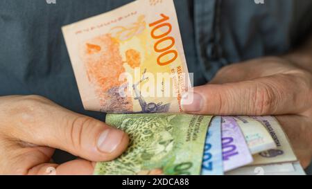 Argentinien Geld, man konvertiert argentinische Pesos, Bargeld in Hand, Finanzgeschäftskonzept, Einkommen und Zustand des Haushalts in Argentinien, Nahaufnahme Stockfoto