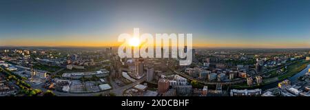 Das Bild zeigt eine weite Stadtlandschaft von Manchester bei Sonnenuntergang und zeigt wichtige Bereiche wie Deansgate und Salford Quays sowie den Great Jac Stockfoto