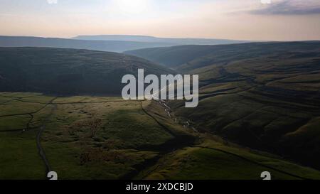 Dieses ruhige Bild fängt einen Blick aus der Vogelperspektive auf einen sich schlängelnden Fluss ein, der durch die grüne Landschaft in der Nähe von Arncliffe schneidet und die ruhige Umgebung unterstreicht Stockfoto