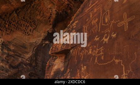 Prähistorische Petroglyphen, die in einem natürlichen Baumkronen am Atlatl Rock im Valley of Fire State Park in Nevada geschützt sind. Stockfoto