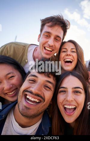 Porträtgruppe verschiedene junge glückliche Menschen, die begeistert auf die Kamera schauen und gemeinsam Spaß im Freien haben. Stockfoto