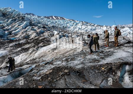 Angesehene Besucher blicken auf ein Trümmerfeld am Colony Glacier, Alaska, 14. Juni 2024. Operation Colony Glacier ist ein Versuch, die Überreste von Soldaten und Wrackteilen eines C-124 Globemaster II zu bergen, der im November 1952 mit 52 Militärmitgliedern an Bord abstürzte. Es wird auf die sichere Bergung von menschlichen Überresten, persönlichen Gegenständen und Ausrüstung an der Unfallstelle geachtet. Die Berücksichtigung überlebender Familienangehöriger der wiedergewonnenen Personen hat bei der Wiedergutmachung der Überreste am Standort oberste Priorität. (Foto der U.S. Air Force von Tech. Sgt. Don Hudson) Stockfoto