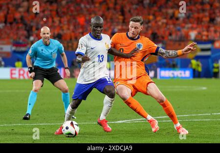 Leipzig, Deutschland. Juni 2024. N’Golo Kante aus Frankreich (C) und Wout Weghorst aus den Niederlanden (C) kämpfen um den Ball, während Schiedsrichter Anthony taylor aus England (L) beim Spiel Niederlande gegen Frankreich Gruppe D 2024 im Stadion Leipzig am 21. Juni 2024 zusieht. (Foto: Dimitrije Vasiljevic) Credit: Dimitrije Vasiljevic/Alamy Live News Stockfoto