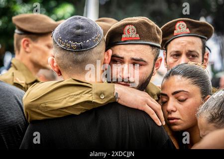 Ein israelischer Soldat umarmt einen Freund während der Beerdigungszeremonie des gefallenen Soldaten Omer Smadga auf dem Militärfriedhof in Netanya. Smadga starb am Donnerstag im Kampf gegen die Hamas im Gazastreifen. Sein Vater, Oren, sprach über sein Grab und rief die IDF auf, so hart wie möglich zu kämpfen. Mach so hart wie möglich weiter. Hör nicht auf, bis wir gewonnen haben. Das ist meine Botschaft an jeden, der im Kampf ist. Am Israel Hai. Oren Smadga ist der israelische Judo-Medaillengewinner der Olympischen Spiele 1992 in Barcelona und aktueller Trainer des israelischen Judo-Teams. Stockfoto