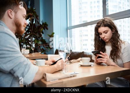 Junge Paare im Café mit ihren Smartphones Stockfoto