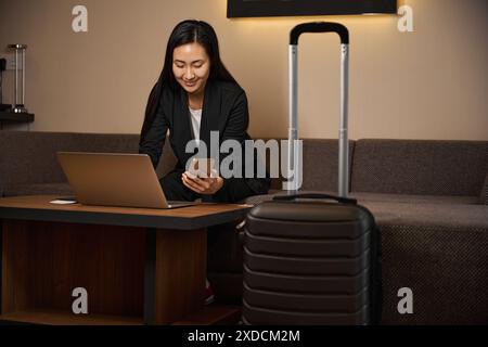 Geschäftsfrau konzentriert sich auf die Arbeit, während sie im Hotel am Laptop sitzt Stockfoto