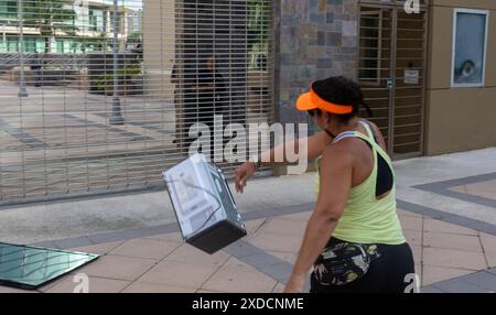 Ein Demonstrant wirft am Freitag, den 21. Juni 2024, eine durch einen Stromausfall beschädigte Mikrowelle in die Zentrale von LUMA Energy in San Juan, Puerto Rico. Seit Hurrikan Maria im Jahr 2017 sind Stromausfälle in Puerto Rico immer häufiger geworden. Viele machen LUMA Energy, die 2021 die Übertragung und Verteilung von Strom übernahm, dafür verantwortlich, dass sie das Stromnetz nicht repariert hat. (Foto: Carlos Berríos Polanco/SIPA USA) Credit: SIPA USA/Alamy Live News Stockfoto