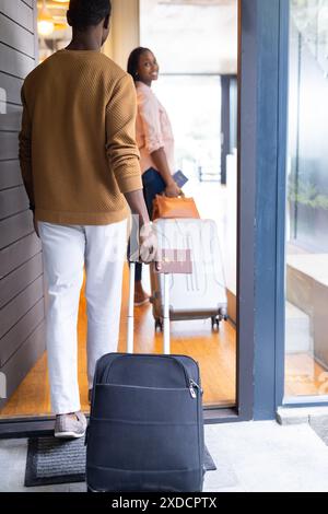 Mit Koffern und Reisepass, das junge Paar verlässt zusammen das Ferienhaus Stockfoto