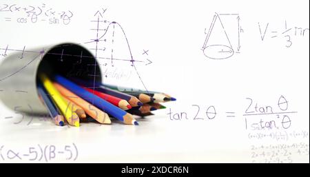 Bild von mathematischen Gleichungen, die über farbigen Bleistiften vor weißem Hintergrund schweben Stockfoto