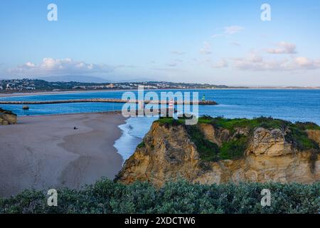 Wunderschöner Meeresstrand in Lagos 'Praia da Batata' mit grasbewachsenen hohen Klippen und wunderschönen Grotten. Panorama auf Strand und Meer. Stockfoto